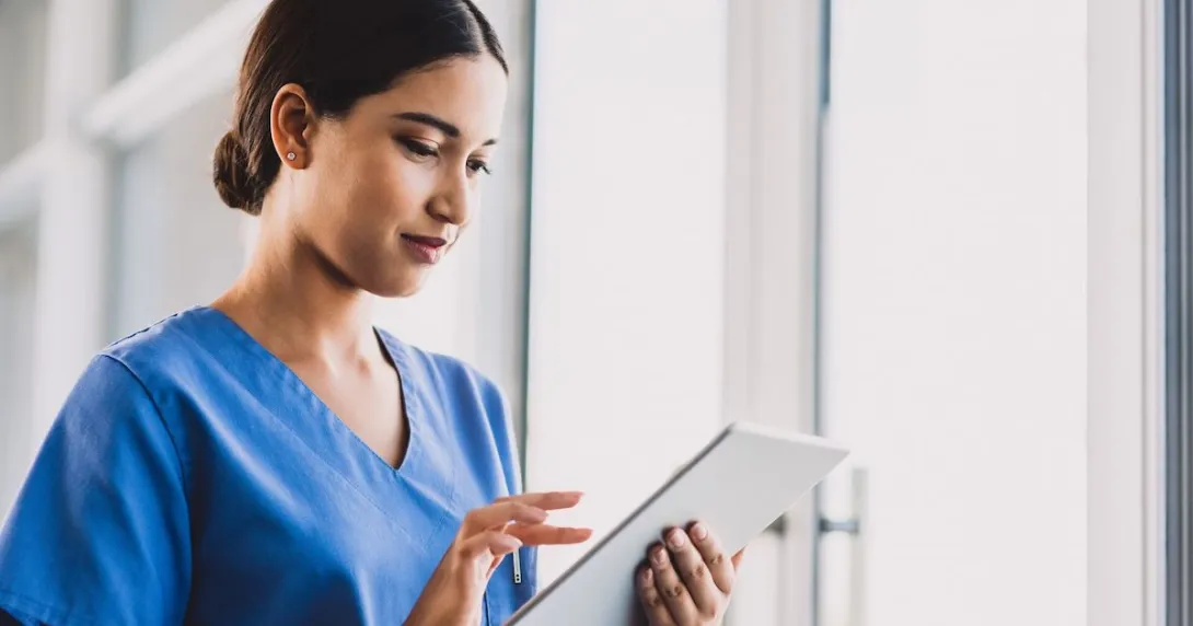 A nurse checking a patient's record on a digital tablet A nurse checking a patient's record on a digital tablet
